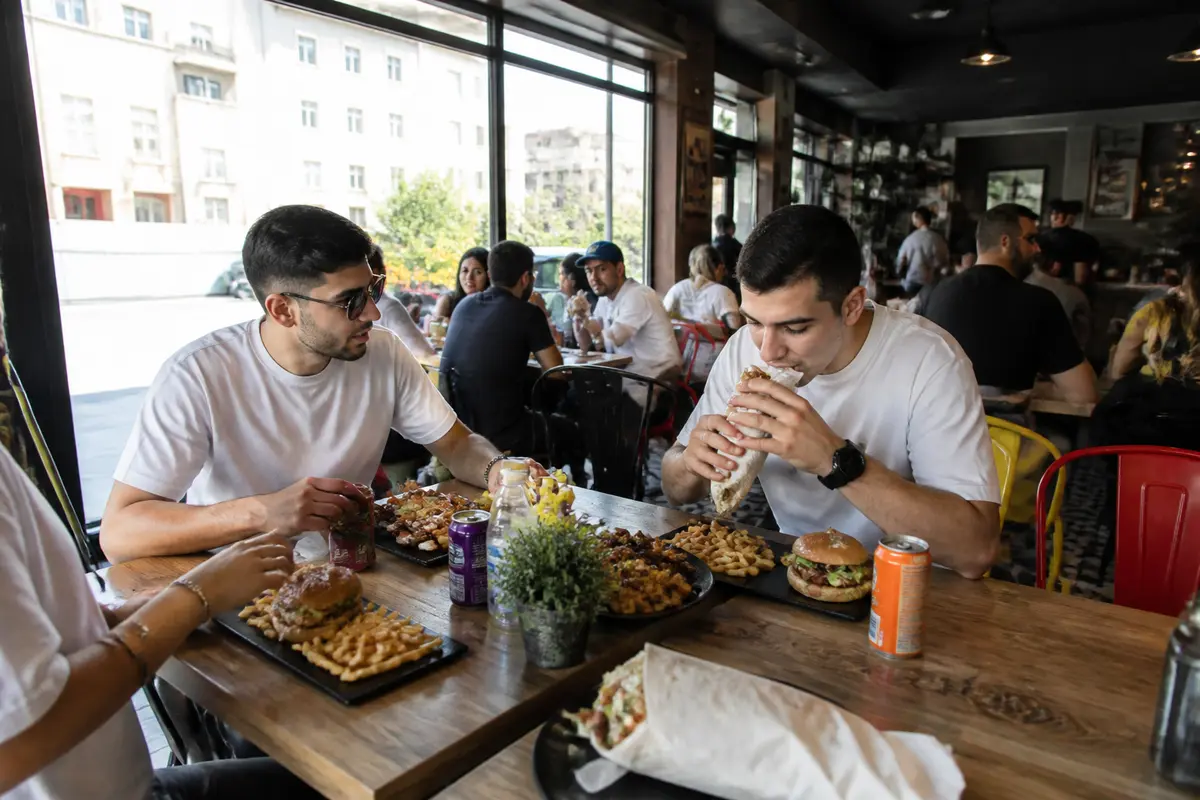 Groupe d'amis dégustant burgers et frites dans un restaurant de fast food à Lille